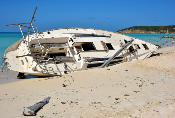 Capsized Sailboat Buried into Sand at Dickenson Bay in St. John’s, Antigua - Encircle Photos