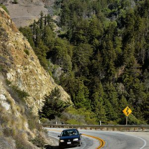 Car with Curve Ahead Sign along Big Sur Coast, California - Encircle Photos