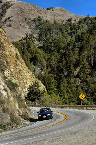 Car with Curve Ahead Sign along Big Sur Coast, California - Encircle Photos