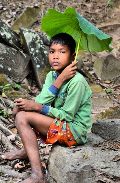 Boy Holding Banyan Leaf as Umbrella at Koh Ker Temples, Cambodia - Encircle Photos