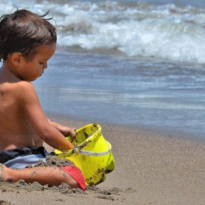 Little Boy Playing with Sand Bucket at Playa El Laucho in Arica, Chile - Encircle Photos