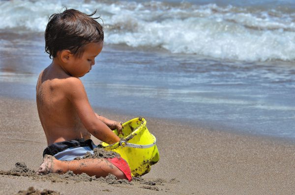 Little Boy Playing with Sand Bucket at Playa El Laucho in Arica, Chile - Encircle Photos