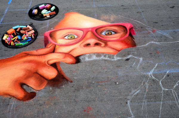 Little Girl Spreads Lips to Show Teeth at Chalk Art Festival in Denver, Colorado - Encircle Photos