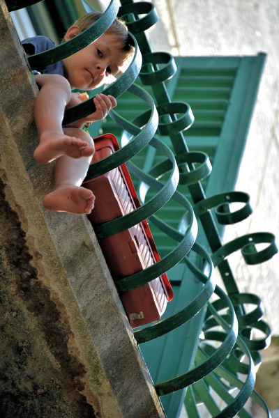 Little Boy Watching from Balcony in Split, Croatia - Encircle Photos