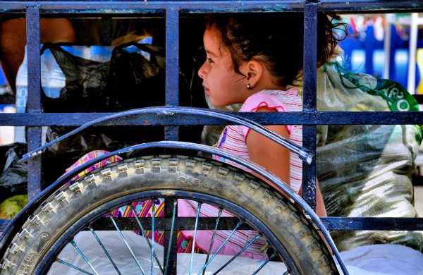 Little Girl Under Vendor Cart on Murciélago Beach in Manta, Ecuador - Encircle Photos