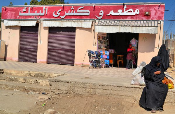 Egyptian Woman Sitting on Curb in Luxor, Egypt - Encircle Photos