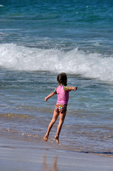 Girl Flying Across Fleming Beach in Kapalua on Maui, Hawaii - Encircle Photos