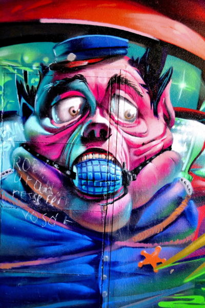 Cartoonish Pink Cop with Bulging Eyes and Mouth Gag Mural in Eger, Hungary - Encircle Photos