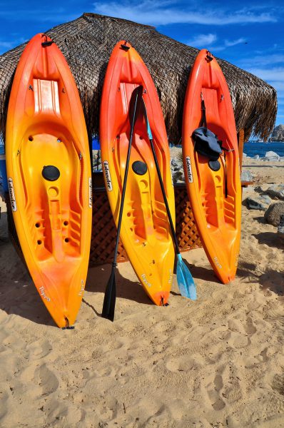 Three Colorful Kayaks against Beach Umbrella in Cabo San Lucas, Mexico - Encircle Photos