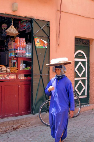 Woman Balancing Bread on Head in Marrakech, Morocco - Encircle Photos