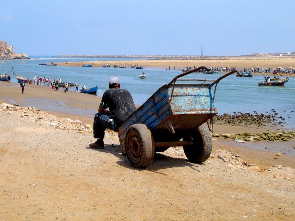 Exhausted Worker Sits on Wheel Barrow on Bou Regreg River in Salé, Morocco - Encircle Photos