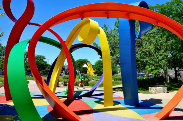 Little Girl Walking in Park Beside Colorful Abstract Art in Omaha, Nebraska - Encircle Photos