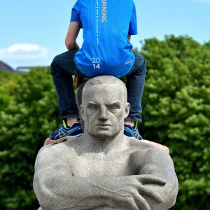 Boy Sitting Backwards on Granite Sculpture at Frogner Park in Oslo, Norway - Encircle Photos