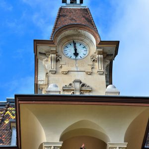 Two Men in Balcony Below Clock Tower in Ouchy, Switzerland - Encircle Photos