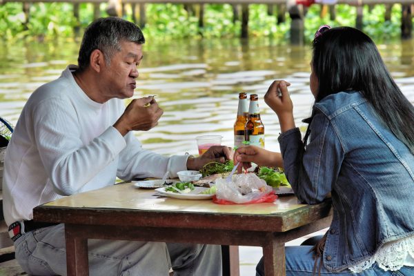 Couple Eating at Taling Chan Floating Market near Bangkok, Thailand - Encircle Photos